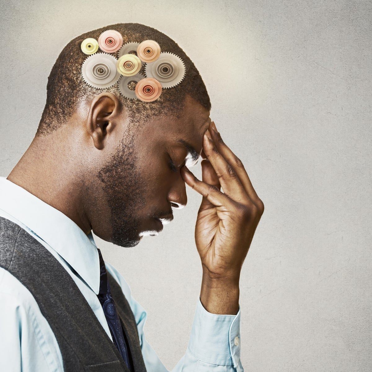 A man with his eyes closed and hand to his forehead, illustrating fatigue and brain fog
