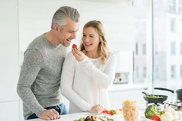 A smiling couple preparing a healthy meal together in their kitchen